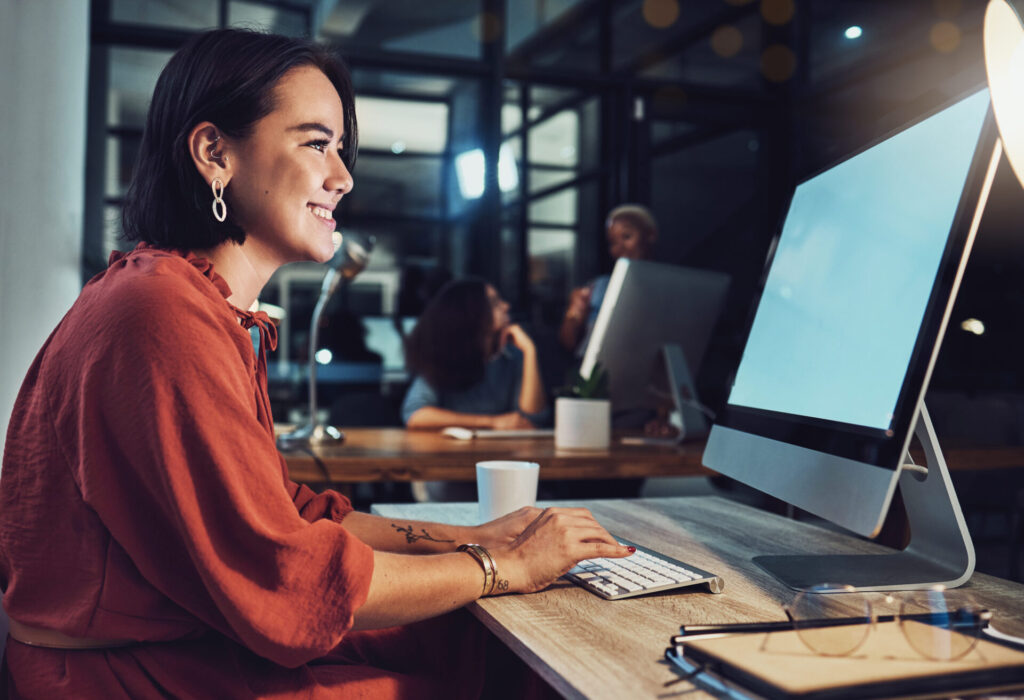 Night, business and woman typing, smile and digital planning for company growth, proposal and website launch. Female employee, consultant and worker with computer, screen or working late for deadline